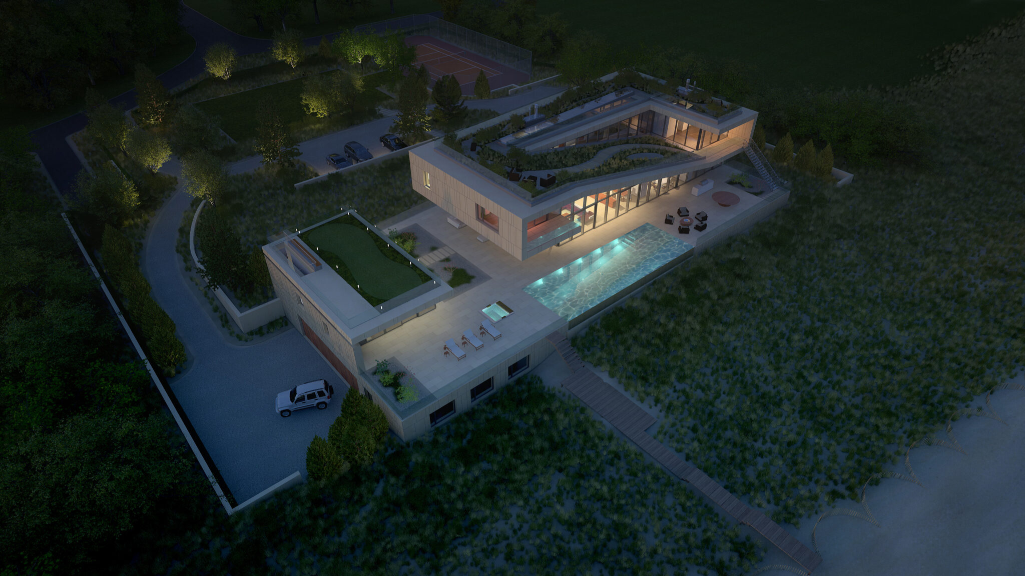 Aerial night view of Long Island House with illuminated interiors, green roof, and pool terrace surrounded by landscaped dunes.