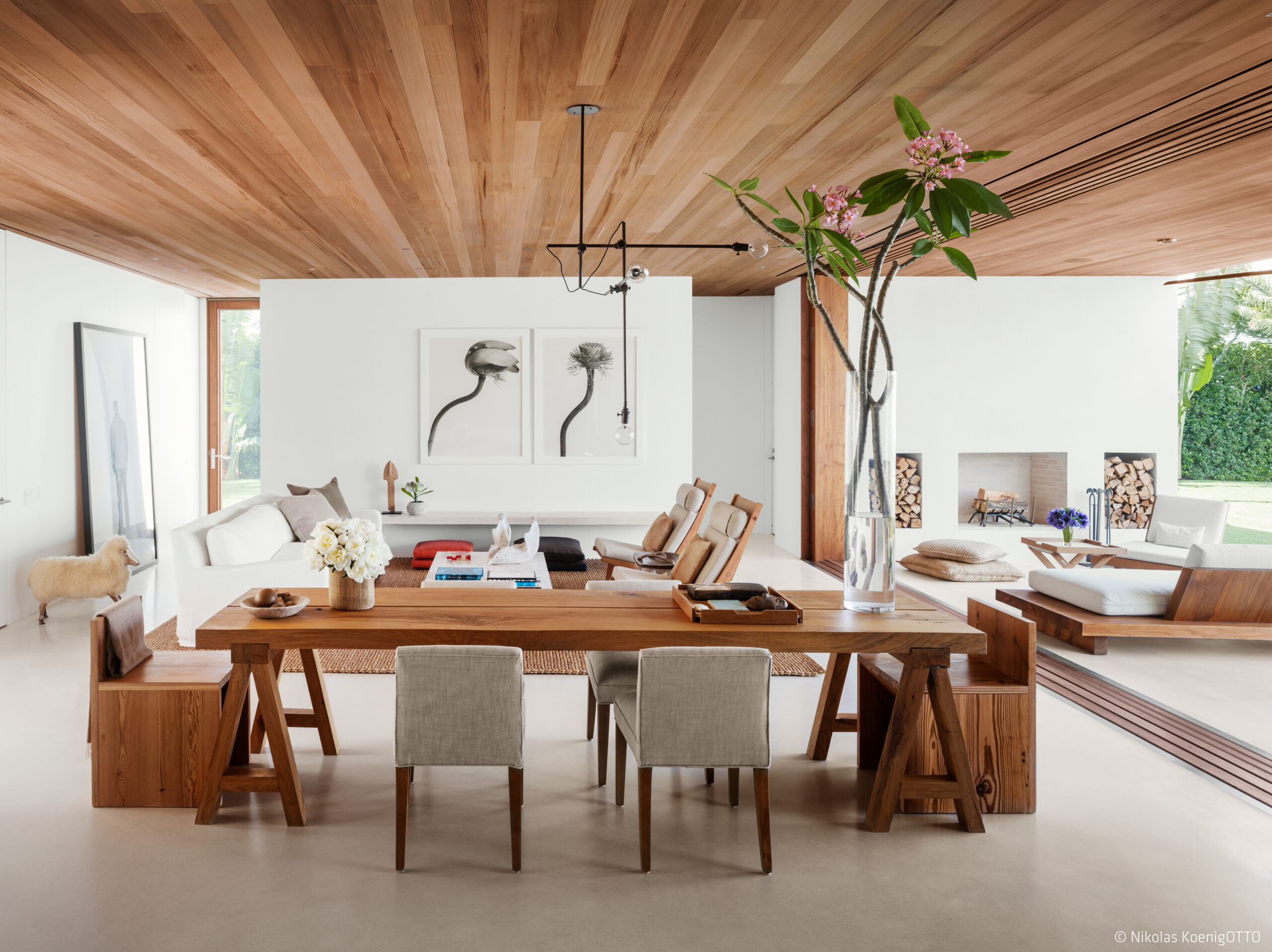 Open-plan living and dining area with wood ceiling, natural textures, and views extending to the garden terrace.
