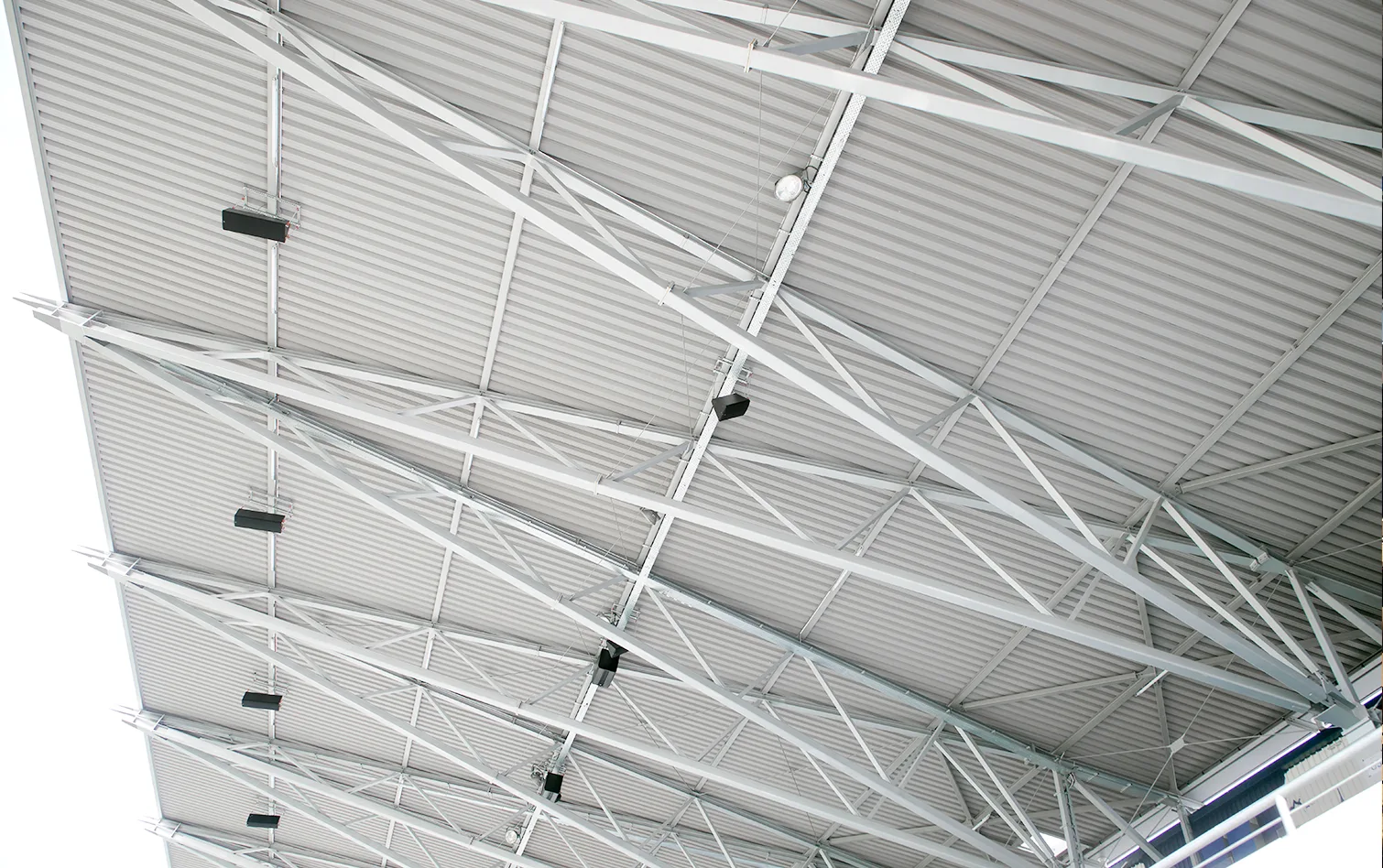 Detailed view of the stadium’s steel roof truss system, showcasing intersecting beams and corrugated panels designed for strength and lightweight durability.
