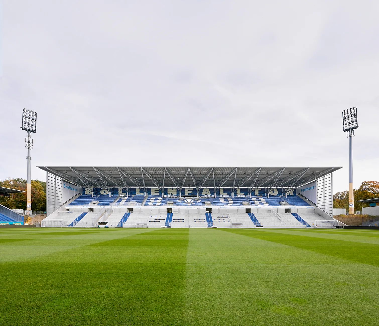 View from the pitch of the opposite grandstand, showing tiered seating and roof canopy.