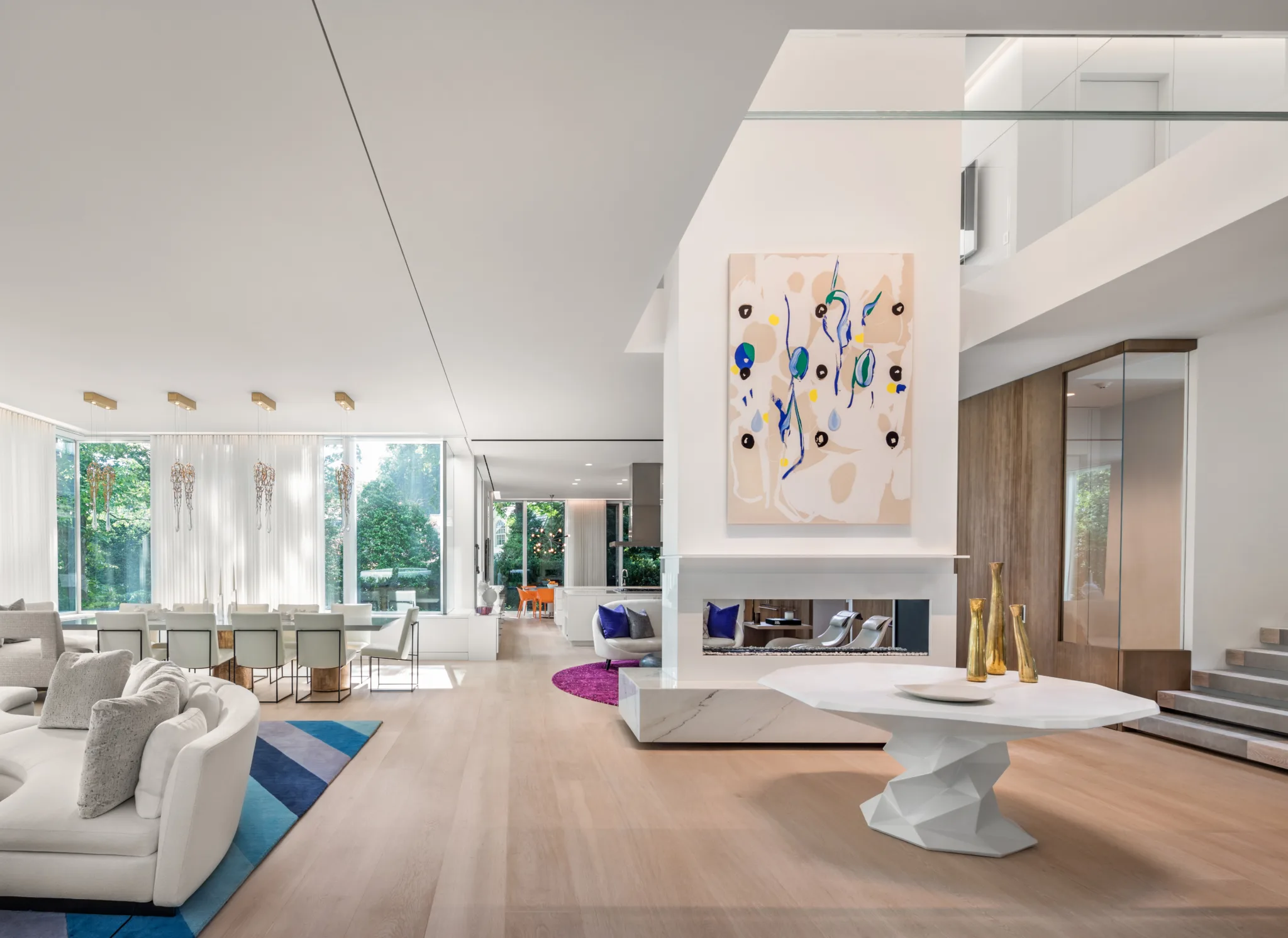 Spacious modern living and dining room with large windows, minimalist furniture, and contemporary artwork