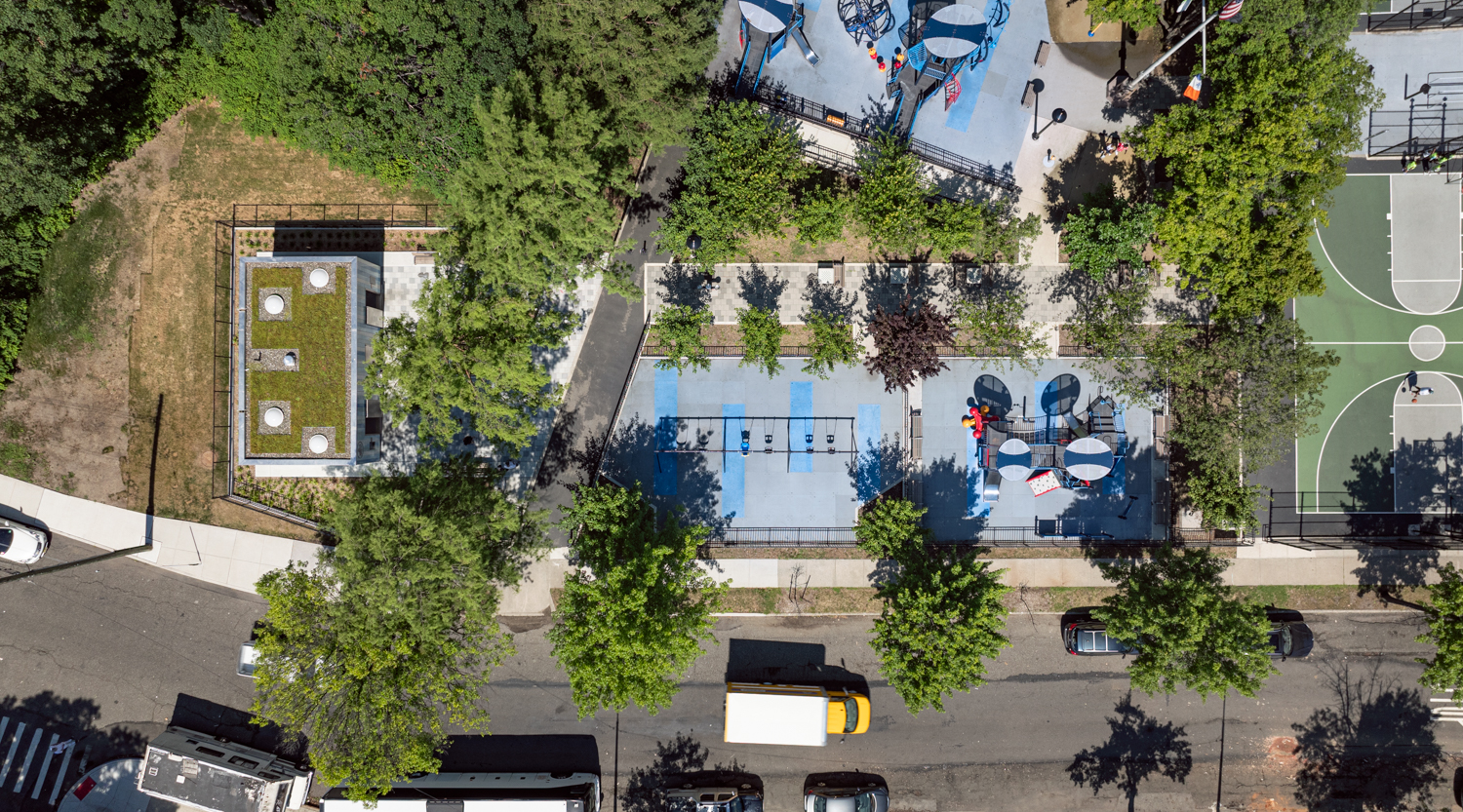 Aerial view of Lopez Playground with comfort station featuring a green roof, surrounded by swings, play areas, and basketball courts.