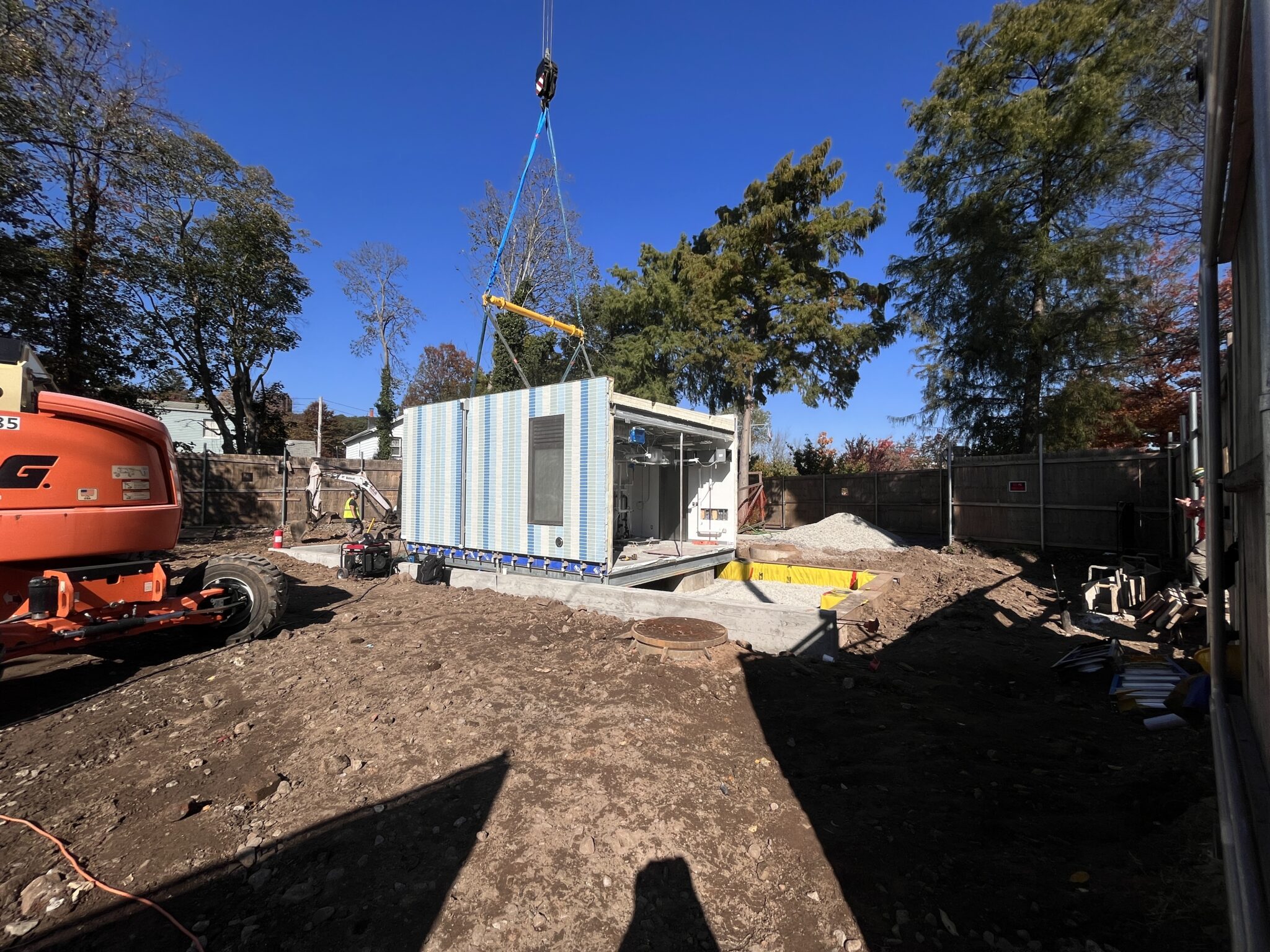 Prefabricated comfort station module being lowered onto its foundation during installation at the park construction site.